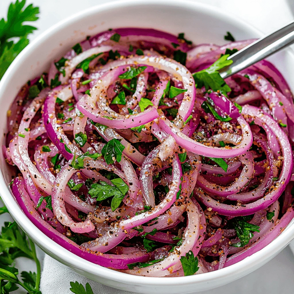 Freshly sliced red onions and parsley tossed in olive oil, lemon, and spices, served in a clean bowl.