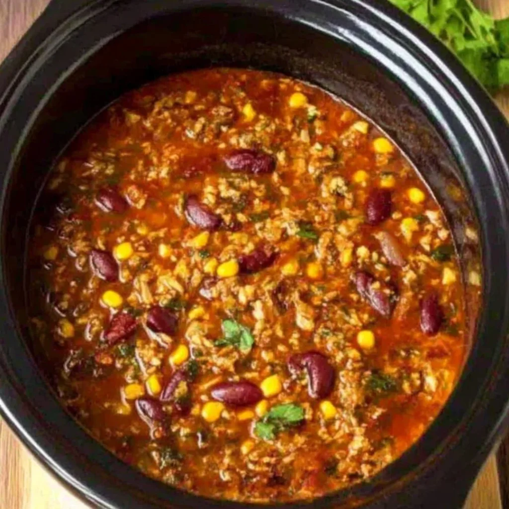 Bowl of Crock Pot taco rice soup topped with cheese and cilantro
