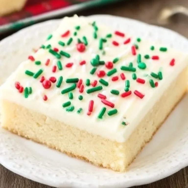 Easy sugar cookie bars on a white plate, decorated with colorful sprinkles.