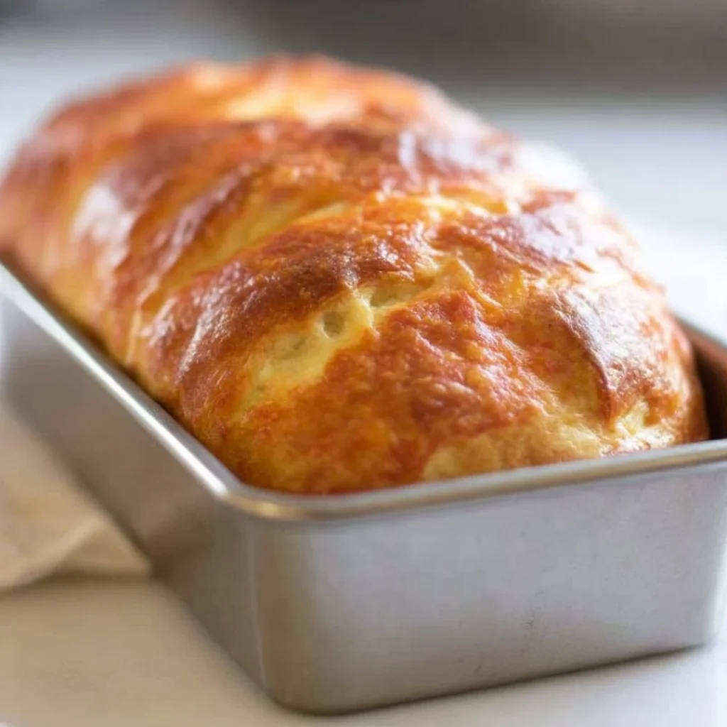 Freshly baked sourdough cheese bread with a golden crust and melty cheese.