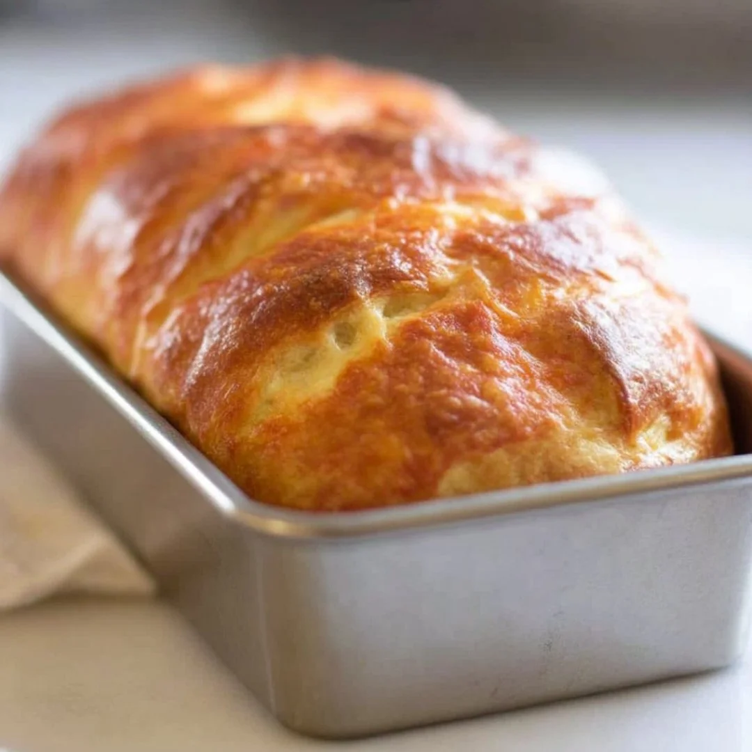 Freshly baked sourdough cheese bread with a golden crust and melty cheese.