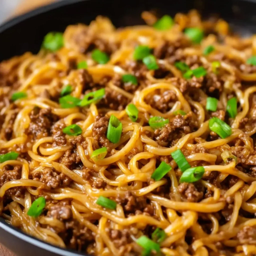 Bowl of cozy Mongolian Ground Beef Noodles garnished with vegetables