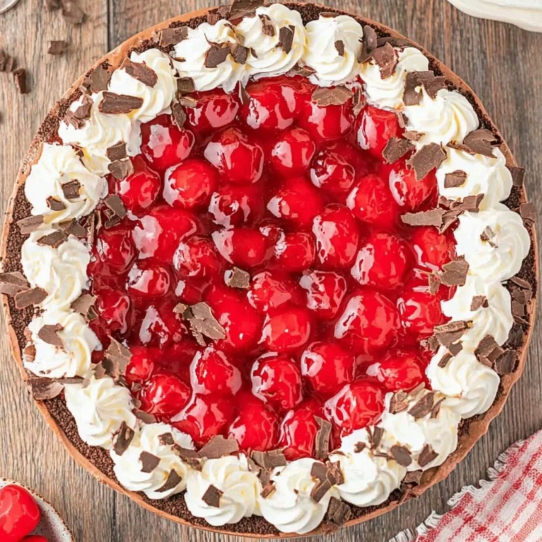 Decadent No Bake Black Forest Cheesecake topped with cherries and chocolate