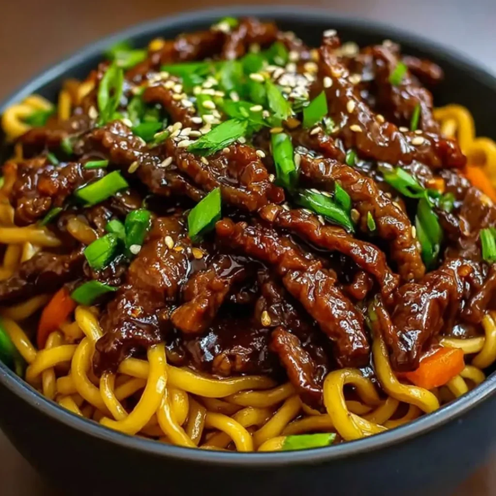 Delicious sticky beef noodles topped with fresh herbs and vegetables