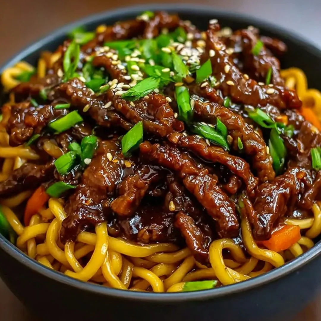 Delicious sticky beef noodles topped with fresh herbs and vegetables