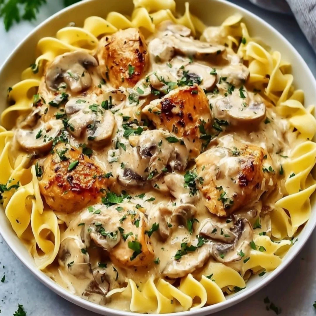 Creamy chicken stroganoff served with pasta and garnished with parsley
