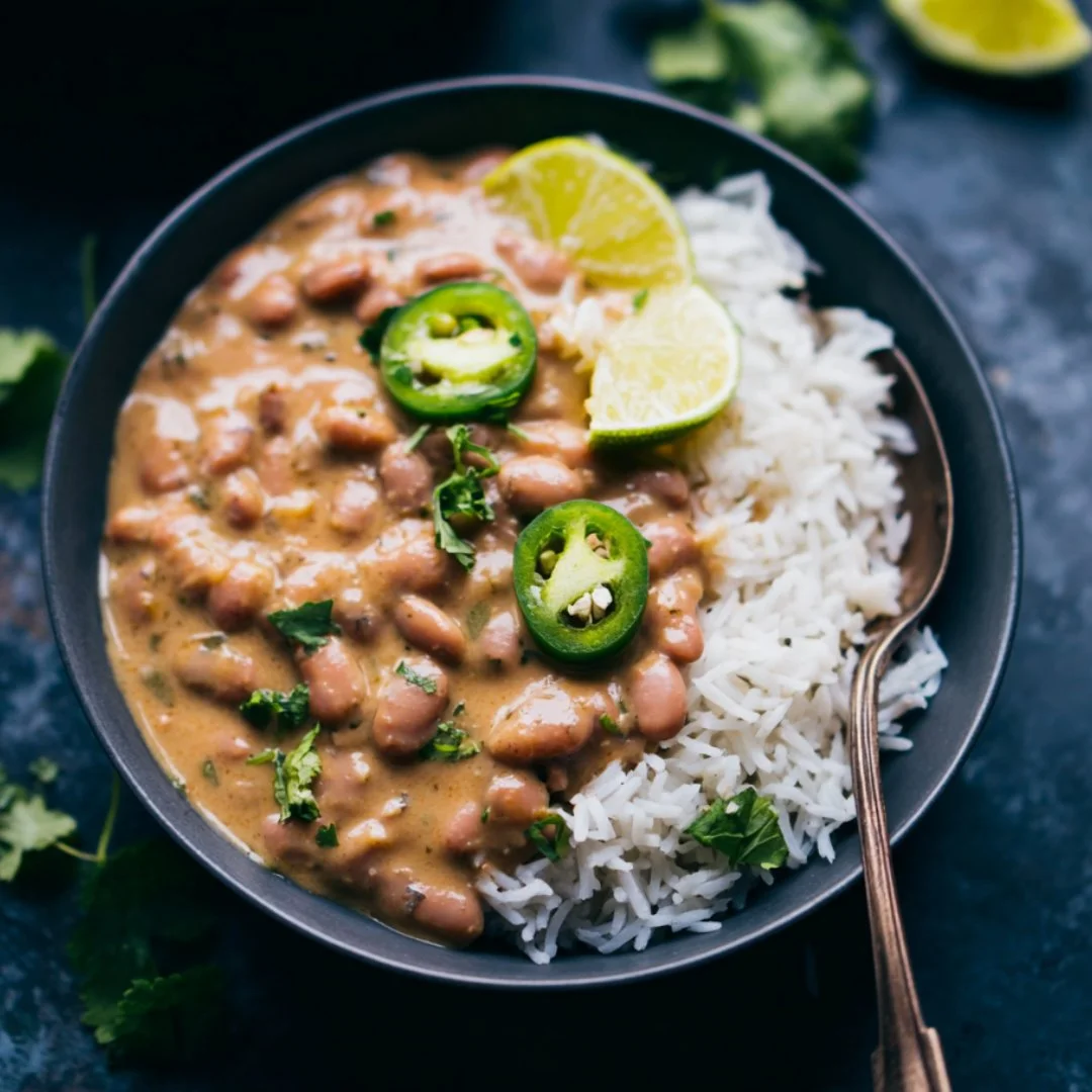 A bowl of rice and beans garnished with herbs and spices.