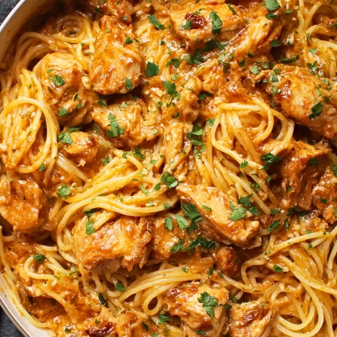 Slow cooker chicken spaghetti dish garnished with herbs and cheese