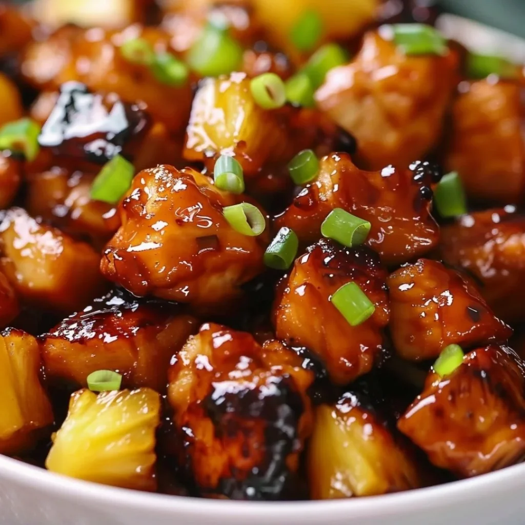 Plate of brown sugar pineapple chicken garnished with herbs and served with rice
