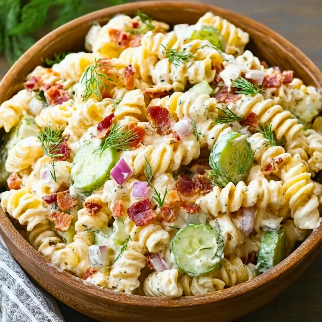 Dill Pickle Bacon Pasta Salad served in a bowl garnished with herbs