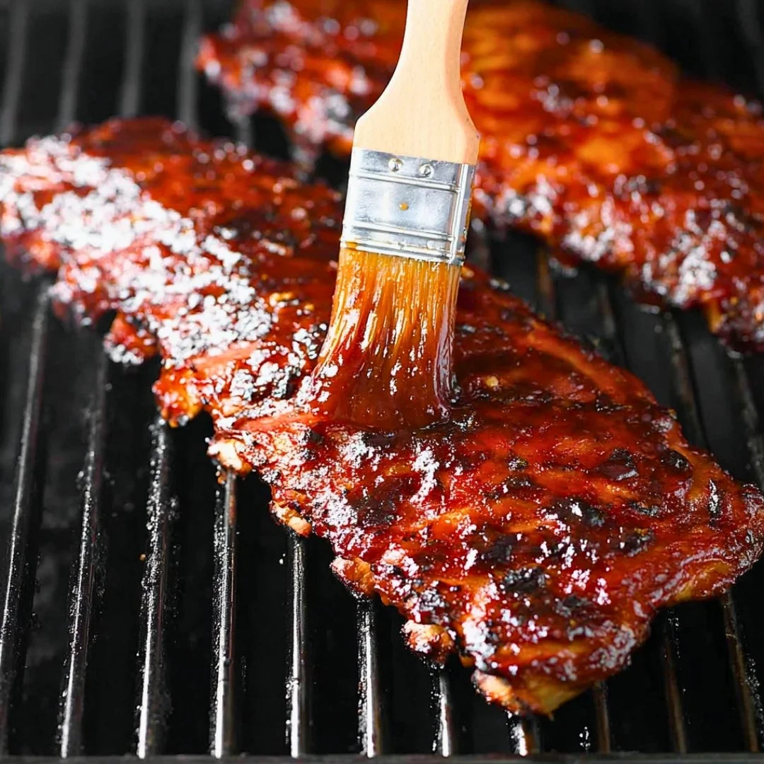 Deliciously grilled ribs served on a platter with barbecue sauce
