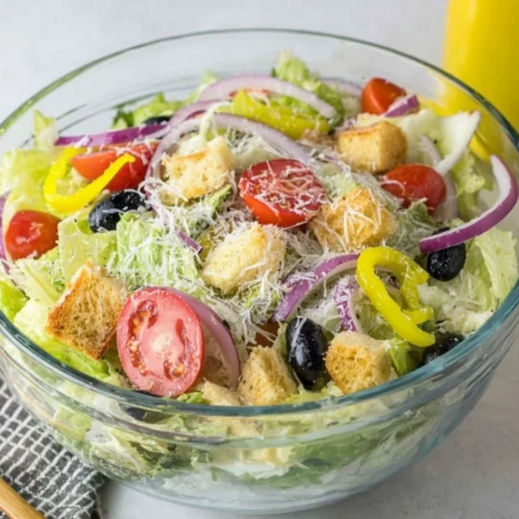 A delicious Olive Garden Salad with fresh greens, olives, and dressing.
