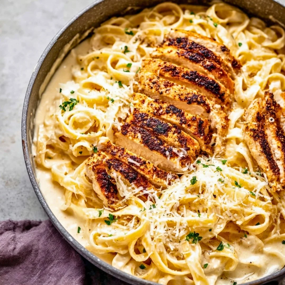 Delicious Chicken Alfredo pasta served with garlic bread and a sprinkle of parsley