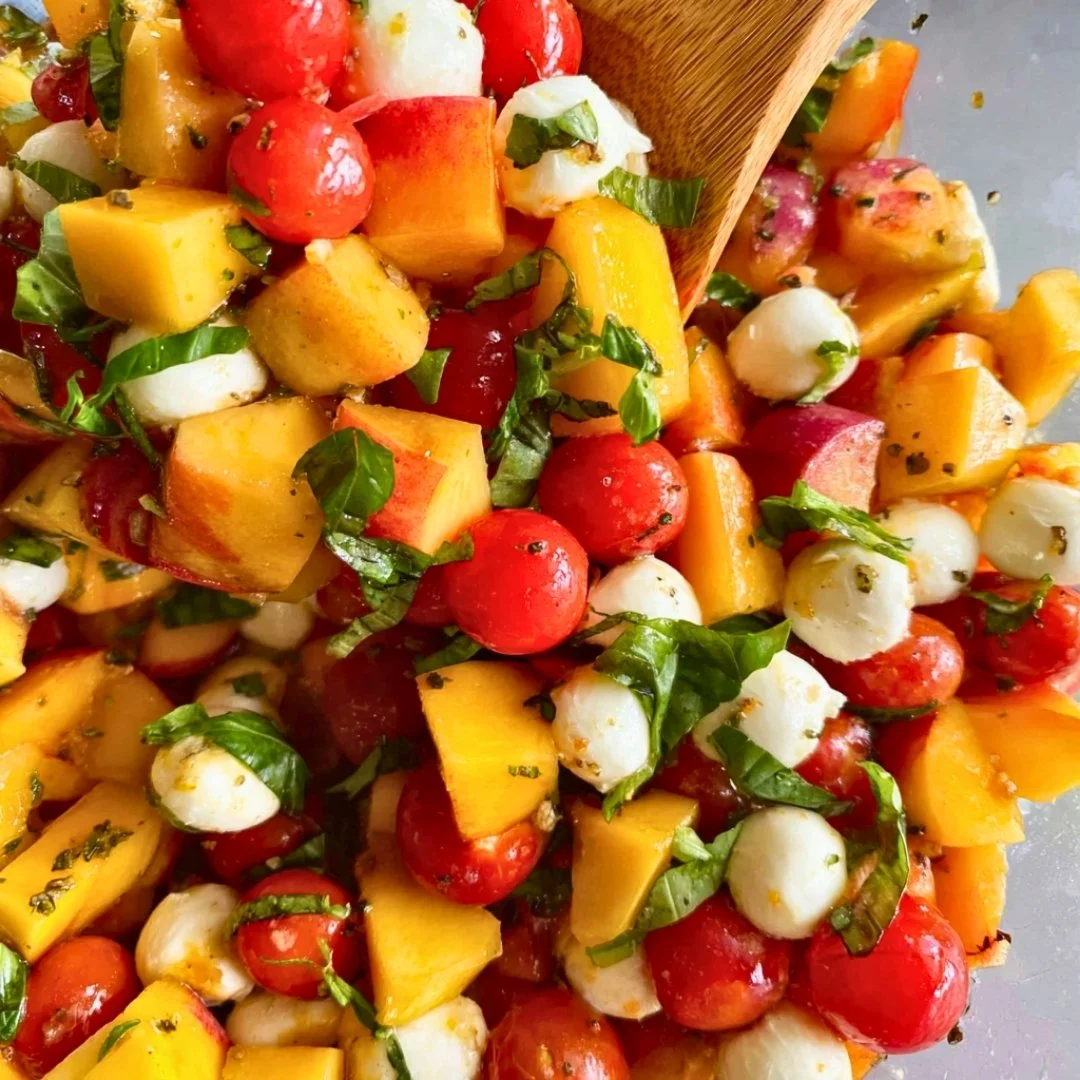 Chopped Peach Caprese Salad with mozzarella, peaches, and basil on a plate