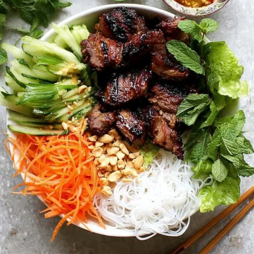 Vietnamese Vermicelli Noodle Salad topped with grilled pork slices and fresh herbs.