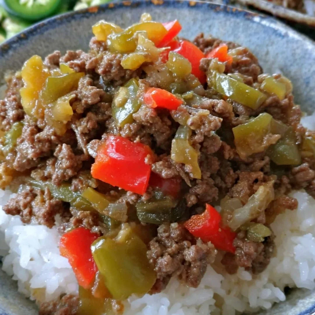 Delicious Beef and Pepper Rice Bowls topped with fresh vegetables and herbs