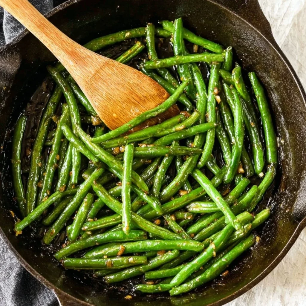 Delicious sauteed green beans in a skillet with garlic and seasoning