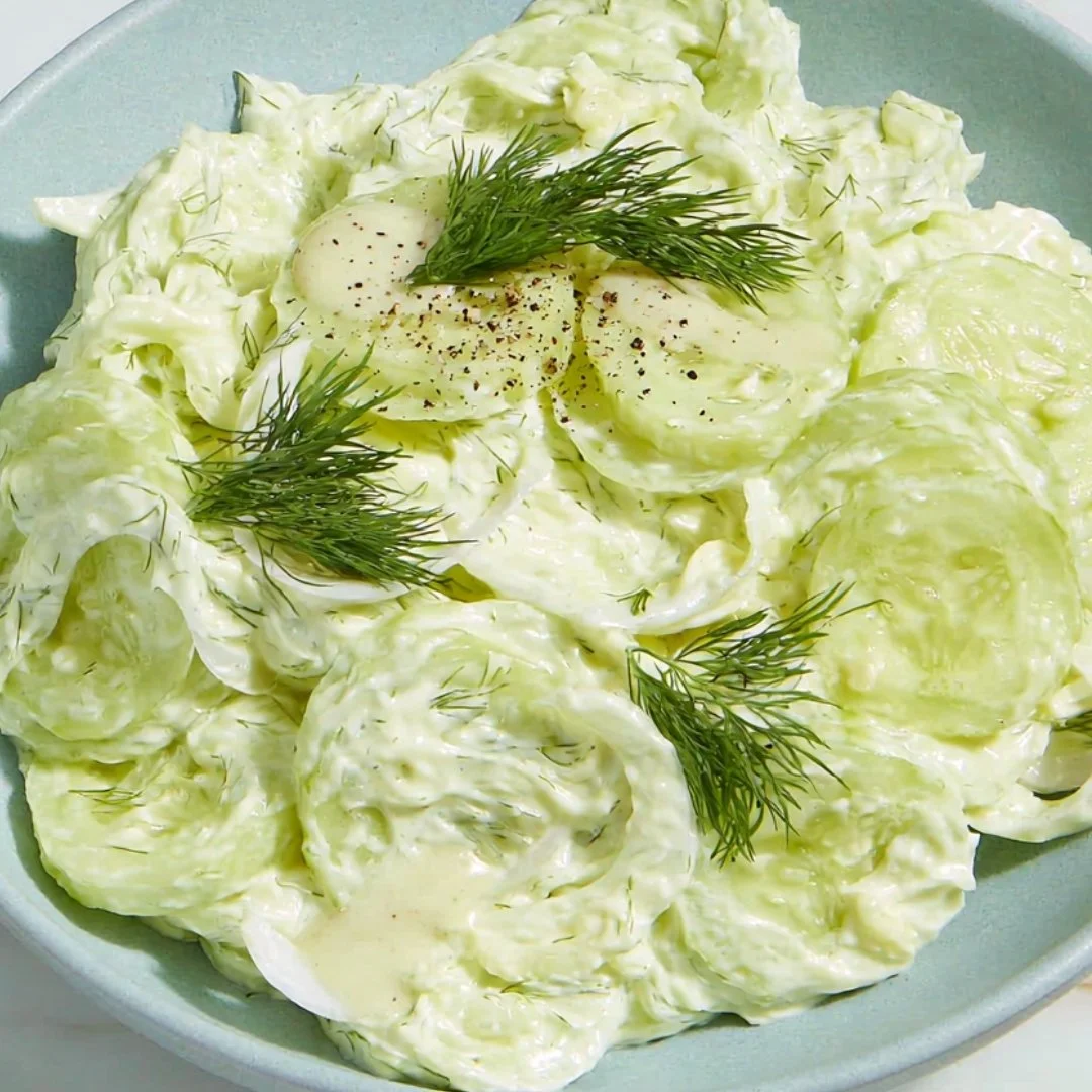 Creamy cucumber salad with fresh ingredients served in a bowl.